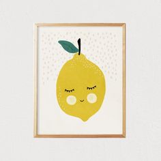 a yellow lemon with eyes closed and a green leaf on it's head is framed in wood