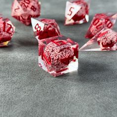 red and white dice sitting on top of a gray table next to other dices