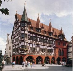 people are walking around in front of an old building