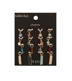 six charms in different colors and shapes on a black card with the words hide & go charms