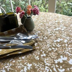 the table is set with silverware and flowers in vases on top of it