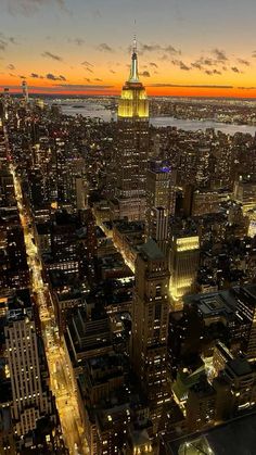 an aerial view of new york city at night with the empire building in the foreground