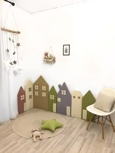 a child's room with wooden flooring and walls painted in different colors, including houses