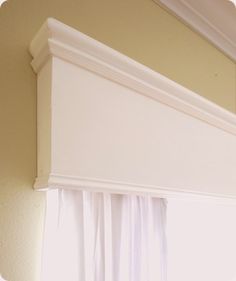 an open window with white drapes on the top and bottom part of the curtain