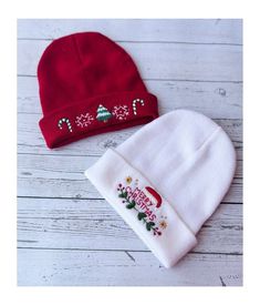 two knitted hats with embroidered designs on the front and back, one red and one white