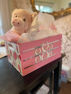 a teddy bear in a pink box on a table