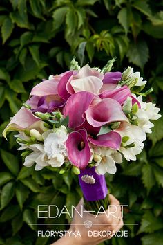 a bridal bouquet with pink and white flowers is held by someone's hand