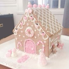 a gingerbread house is decorated with pink icing