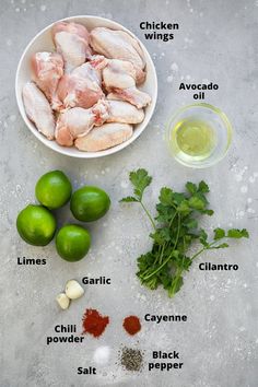 ingredients to make chicken wings laid out in bowls on a gray surface with limes, cilantro, garlic and salt