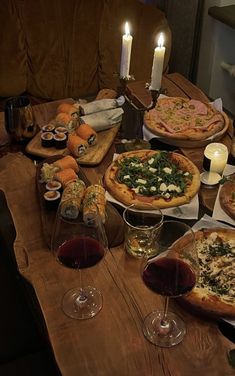 a table topped with lots of pizza and glasses of wine next to eachother