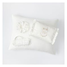 a white pillow with embroidered appliques and ruffle trimmings on it