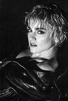 a black and white photo of a woman wearing a leather jacket