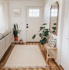 a living room filled with furniture and a rug on top of a hard wood floor