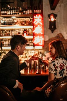 a man and woman sitting at a bar