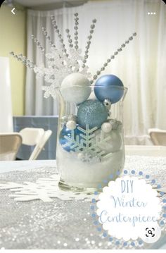 a vase filled with ornaments sitting on top of a table next to a window covered in snow