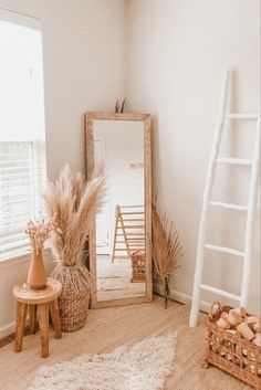 a room with a ladder, mirror and other items in front of the window on the floor