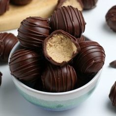 a bowl full of chocolate truffles with peanut butter in the center and on the side