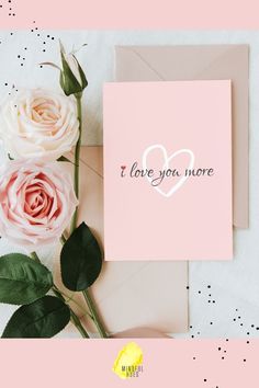 a pink card with the words i love you more on it next to some flowers