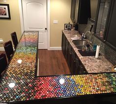 the counter top is made out of many different colored soda cans, and it looks like they have been painted on