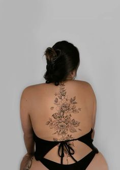 the back of a woman's body with tattoos on her upper and lower half