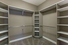 an empty walk in closet with shelves and hanging bars