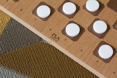 a close up of a wooden board game with white circles on it and brown squares in the middle