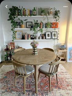 a dining room table and chairs with bookshelves in the background