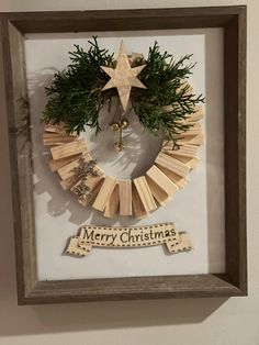 a christmas wreath made out of popsicle sticks and wooden dows in a shadow box