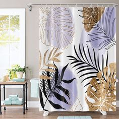 the shower curtain is decorated with gold and black leaves on white background, along with a blue rug