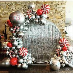 a christmas wreath made out of silver and red balls, candy canes and balloons