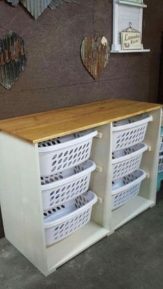 a white cabinet with baskets on top of it in front of a wooden sign that says love