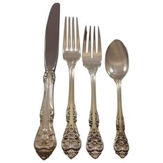 an assortment of silverware including spoons, forks and knives with floral designs on them