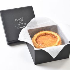 a small pastry in a black box on a white surface with the lid open to show it's filling