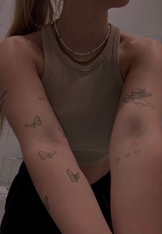 a woman with tattoos on her arm in the bathroom