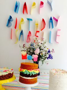 a birthday cake sitting on top of a table next to a vase filled with flowers