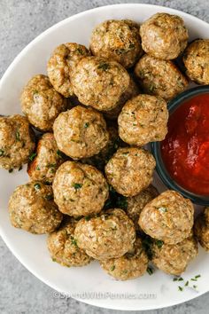 a white plate topped with meatballs and ketchup