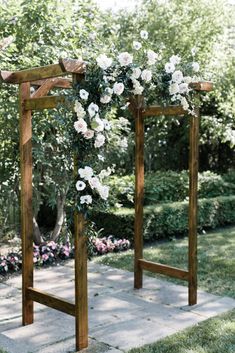 an outdoor wedding ceremony setup with white flowers and greenery