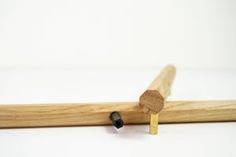 a piece of wood sticking out of the side of a wooden stick on a white surface