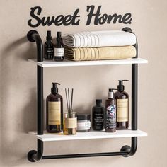 two shelves with towels, soaps and other bathroom items on them against a wall