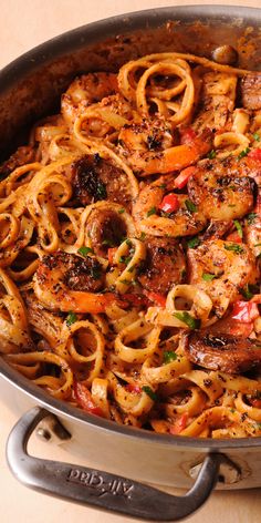 a pan filled with pasta and meat on top of a table