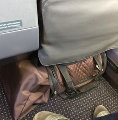 someone is sitting on an airplane with their handbag