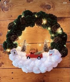 a christmas wreath with a red truck and trees in the middle is hung on a wooden wall