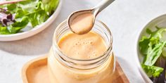 a jar filled with peanut butter next to a salad