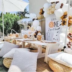 a table set up with white and gold balloons for a birthday party or baby shower