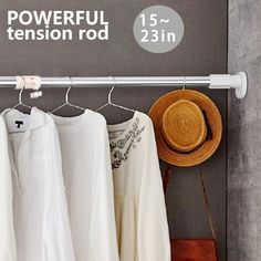 clothes hanging on a rack in front of a sign that says powerful tension rod