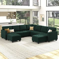 a large green sectional couch sitting in a living room next to a tall glass window