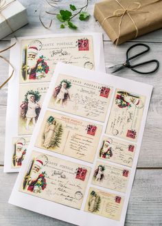 some old fashioned christmas postcards are laying on a table with scissors and other items