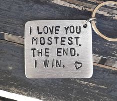 a metal keychain with the words i love you most, the end i win on it