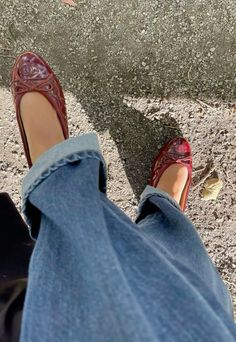 a person wearing red shoes and jeans standing next to each other with their feet on the ground