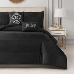 a bed with black comforter and pillows on it